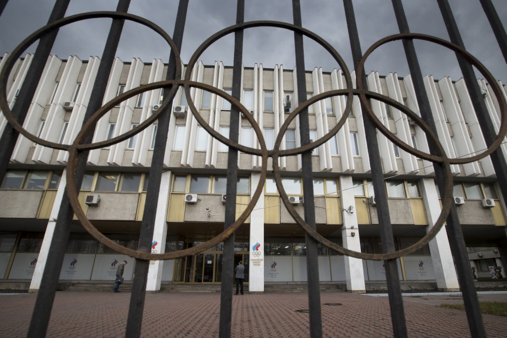 FILE - In this Nov. 13, 2015, file photo,pPeople walk in front of the Russian Olympic Committee building in Moscow. Leaders of the world anti-doping movement called for Russian track athletes to be banned from next year's Olympics, saying Monday, Nov. 16, 2015, that the nine-month window between now and the games isn't enough to ensure the program and its athletes are clean.  (AP Photo/Pavel Golovkin, File)