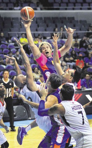 ASI Taulava of NLEX goes for a shot off Kelly Nabong and Bryan Faundo of Meralco in yesterday’s match at Smart Araneta Coliseum. AUGUST DELA CRUZ 