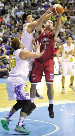 Ginebra giant Greg Slaughter beats Jewel Ponferada and Beau Belga of Rain or Shine to the rebound in last night’s game. AUGUST DELA CRUZ/INQUIRER