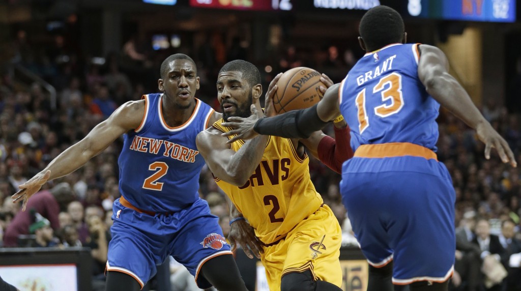 Cleveland Cavaliers' Kyrie Irving, center, drives between New York Knicks' Langston Galloway, left, and Jerian Grant in the first half of an NBA basketball game Wednesday, Dec. 23, 2015, in Cleveland. (AP Photo/Tony Dejak)