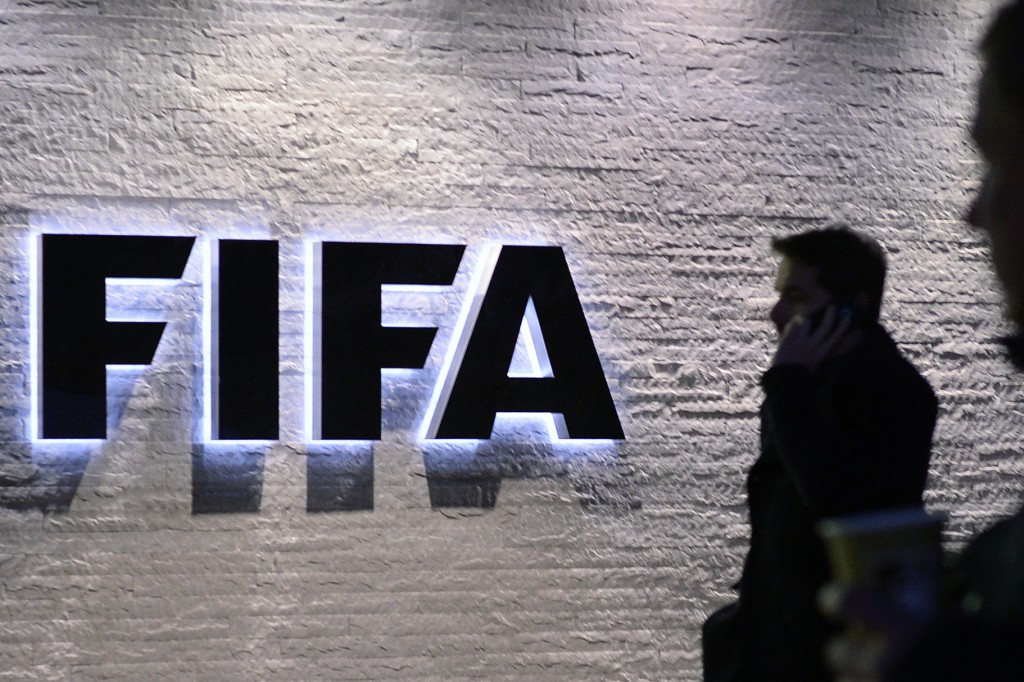 In this Dec. 2, 2015 photo a man stands in front of the logo at the FIFA headquarters "Home of FIFA" in Zurich, Switzerland. AP 