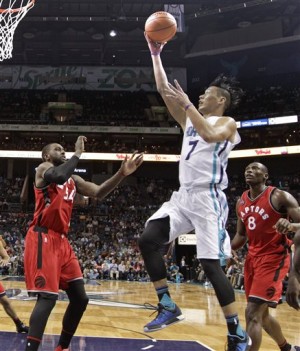 Charlotte Hornets' Jeremy Lin (7) drives past Toronto Raptors' Bismack Biyombo (8) and Patrick Patterson (54) during the second half of an NBA basketball game in Charlotte, N.C., Thursday, Dec. 17, 2015. The Hornets won 109-99 in overtime. (AP Photo/Chuck Burton)