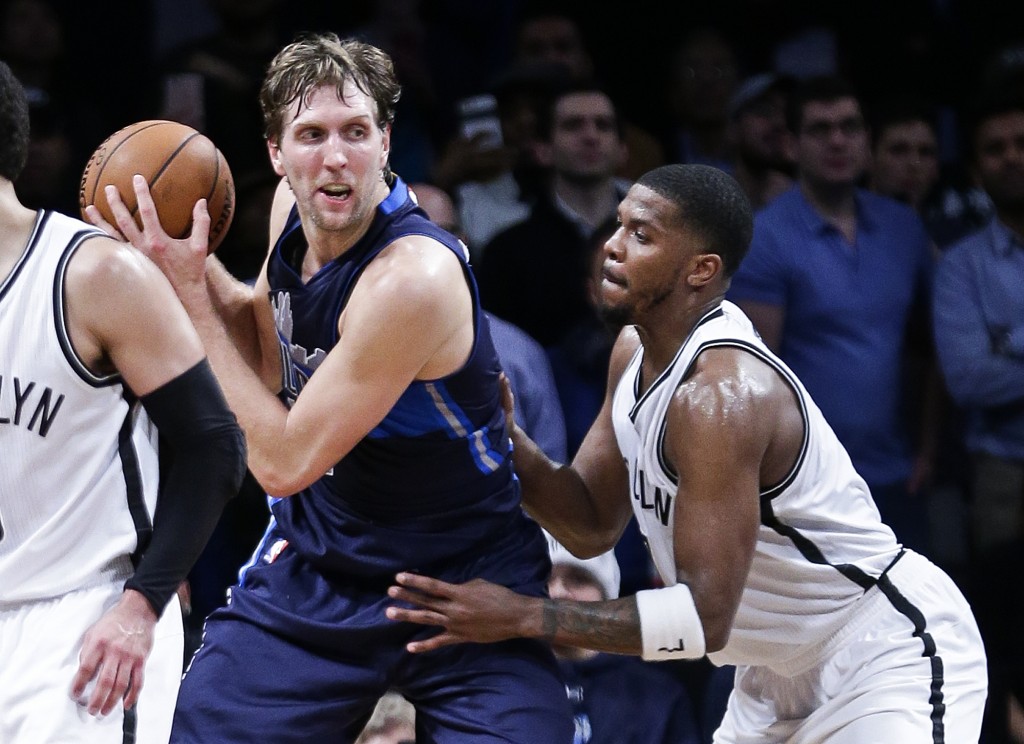 Dallas Mavericks' Dirk Nowitzki, seond from right, is defended by Brooklyn Nets' Joe Johnson (7) during the overtime period of an NBA basketball game Wednesday, Dec. 23, 2015, in New York. The Mavericks won 119-118. (AP Photo/Frank Franklin II)