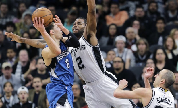 Minnesota Timberwolves guard Zach LaVine (8) looks for a shot against San Antonio Spurs defenders Kawhi Leonard (2) and Manu Ginobili during the second half of an NBA basketball game Monday, Dec. 28, 2015, in San Antonio. San Antonio won 101-95. (AP Photo/Eric Gay)