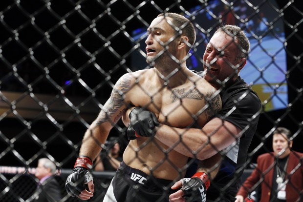 Frankie Edgar, left, celebrates with a member of his corner after Edgar defeated Chad Mendes in a featherweight bout during The Ultimate Fighter finale Friday, Dec. 11, 2015, in Las Vegas. (AP Photo/John Locher)