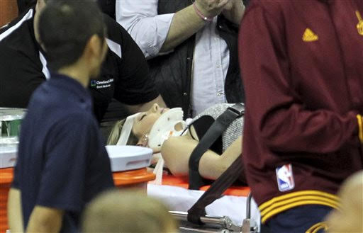 Ellie Day, wife of PGA Tour golf player Jason Day, is carried off the floor in a stretcher after Cleveland Cavaliers' LeBron James collided with her out of bounds. The Plain Dealer via AP