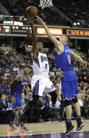 Sacramento Kings’ Rajon Rondo, center, drives to the basket against New York Knicks’ Kristaps Porzingis. AP