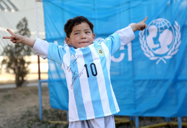 In this provided by UNICEF, Murtaza Ahmadi, an Afghan Lionel Messi fan, shows a donated and signed shirt by Messi, in Kabul, Afghanistan, Thursday, Feb. 25, 2016. (Mahdy Mehraeen/UNICEF via AP)