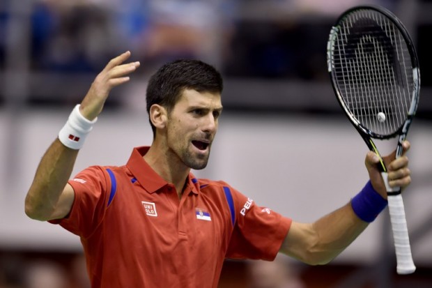 Serbia's tennis player Novak Djokovic reacts after winning a point with his team mate Nenad Zimonjic against Kazakhstan's team composed by Aleksandr Nedovyesov and Andrey Golubev during the Davis Cup World Group first round double match between Serbia and Kazakhstan at "Aleksandar Nikolic" hall in Belgrade, on March 5, 2016.   / AFP / ANDREJ ISAKOVIC