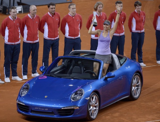 (FILES) This file photo taken on April 27, 2014 shows Russia's Maria Sharapova holding her trophy while posing with the winner's price, a Porsche 911 Targa sportscar, after winning the final of the WTA Porsche Tennis Grand Prix in Stuttgart, southwestern Germany. German car manufacturers Porsche became on March 8, 2016 the third big-name sponsor to distance themselves from Maria Sharapova after the tennis star admitted failing a doping test at the Australian Open. / AFP / THOMAS KIENZLE