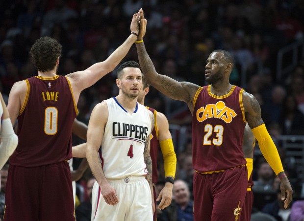 Cleveland Cavaliers' LeBron James, right, and Kevin Love celebrate after James scores a basket as Los Angeles Clippers' J.J. Redick looks on in an NBA basketball game in Los Angeles, on Sunday, March 13, 2016. (Kyusung Gong/The Orange County Register via AP) MANDATORY CREDIT