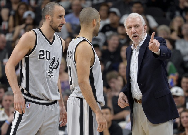 San Antonio Spurs head coach Gregg Popovich, right, talks to Spurs guards Manu Ginobili (20), of Argentina, and Tony Parker, of France, during the second half of an NBA basketball game against the Sacramento Kings, Saturday, March 5, 2016, in San Antonio. (AP Photo/Darren Abate)