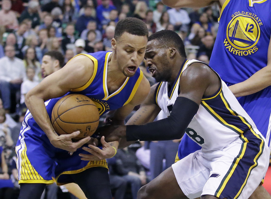 Golden State Warriors guard Stephen Curry, left, steals the ball from Utah Jazz guard Shelvin Mack (8) during the first quarter of an NBA basketball game Wednesday, March 30, 2016, in Salt Lake City. (AP Photo/Rick Bowmer)