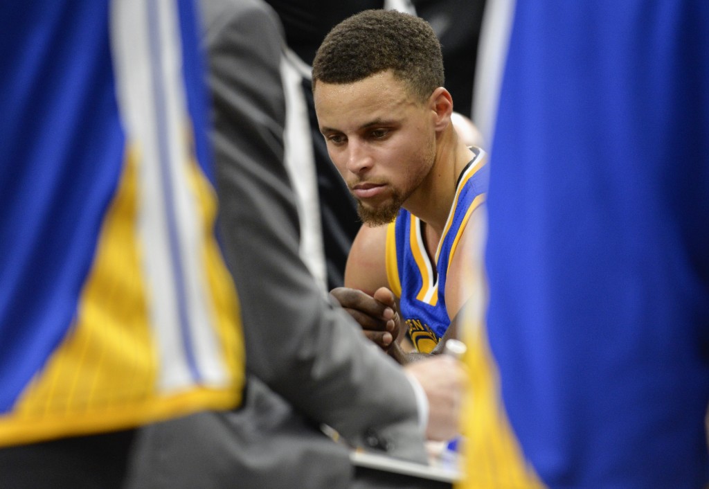 Golden State Warriors guard Stephen Curry sits on the bench during a timeout in the second half of an NBA basketball game against the San Antonio Spurs, Saturday, March 19, 2016, in San Antonio. San Antonio won 87-79. (AP Photo/Darren Abate)