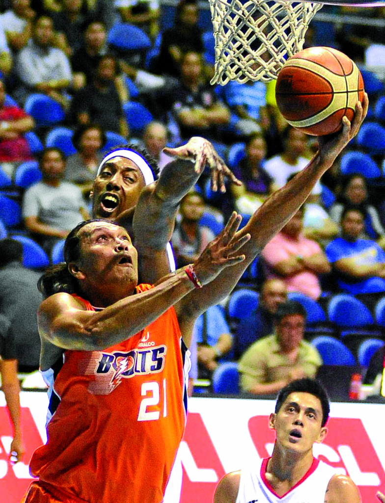 MERALCO’S Reynel Hugnatan (front) tries an undergoal stab against Alaska’s Rob Dozier. Dozier and the Aces nailed the key win. AUGUST DELA CRUZ