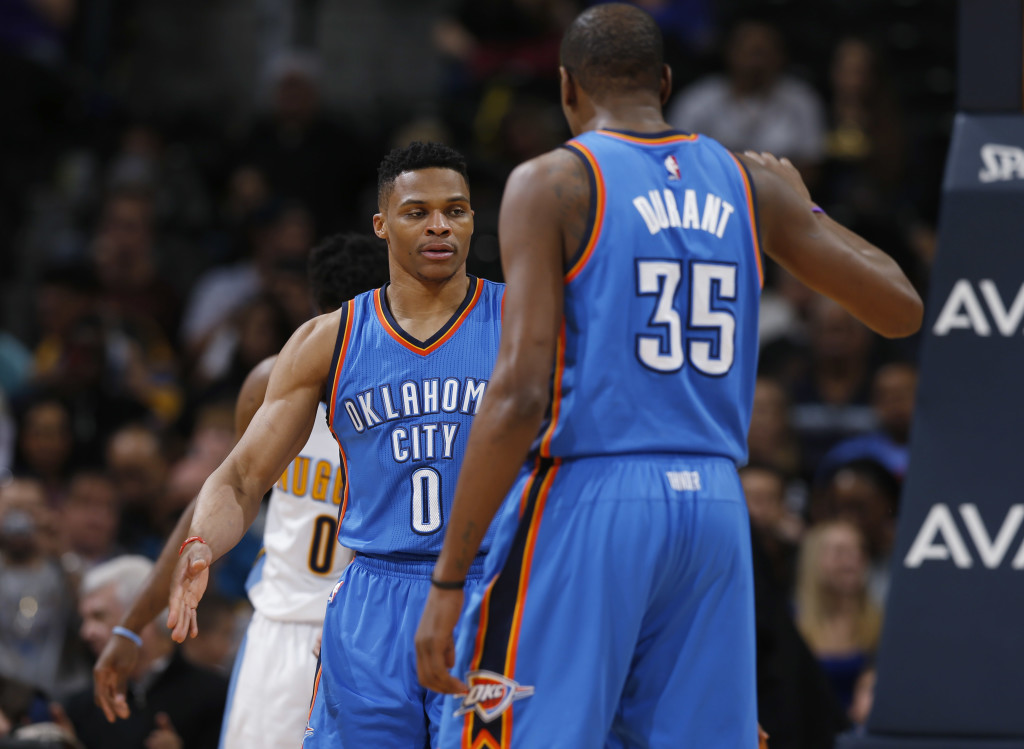 Oklahoma City Thunder guard Russell Westbrook, back, is congratulated, after scoring a basket and drawing a foul, by forward Kevin Durant during the second half of an NBA basketball game against the Denver Nuggets on Tuesday, April 5, 2016, in Denver. Oklahoma City won 124-102. (AP Photo/David Zalubowski)
