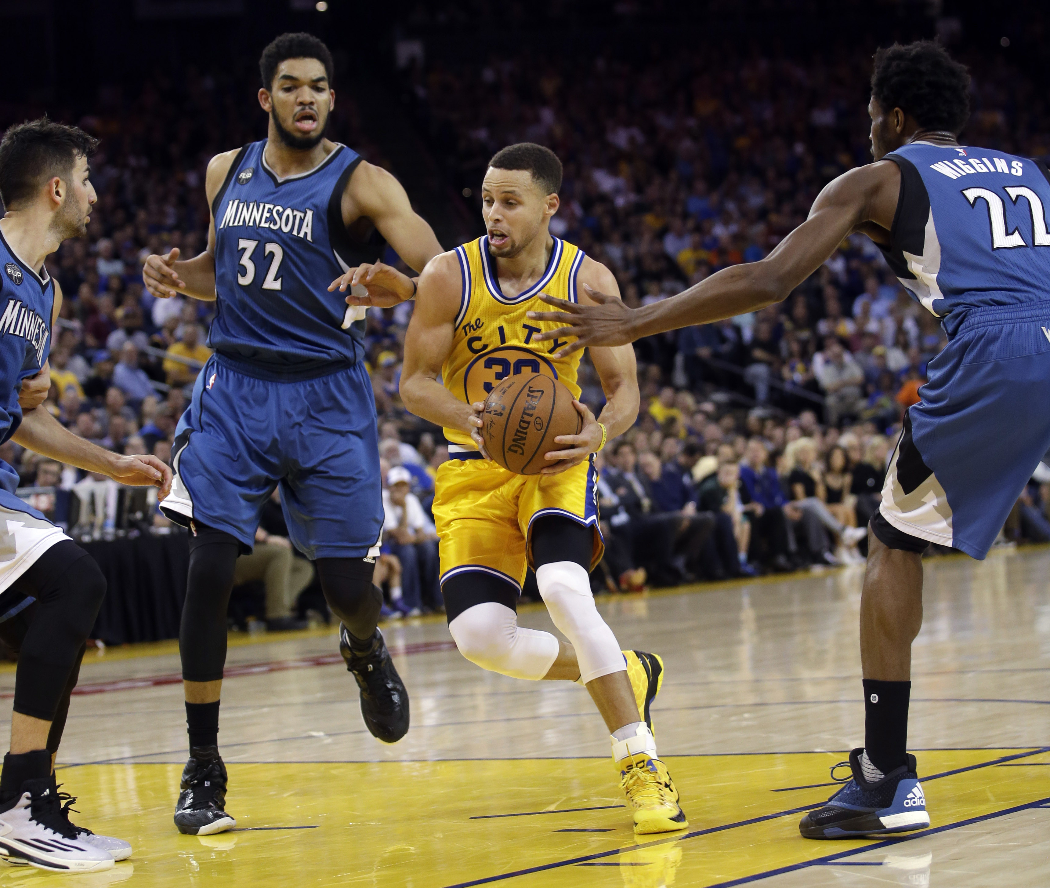 Golden State Warriors' Stephen Curry is surrounded by Minnesota Timberwolves defenders as he drives to the basket during the second half of an NBA basketball game Tuesday, April 5, 2016, in Oakland, Calif. AP