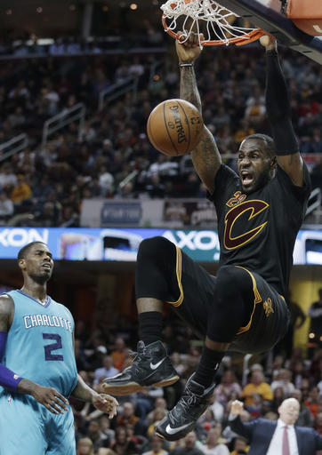 Cleveland Cavaliers' LeBron James, right, dunks as Charlotte Hornets' Marvin Williams (2) watches in the second half of an NBA basketball game Sunday, April 3, 2016, in Cleveland. AP 