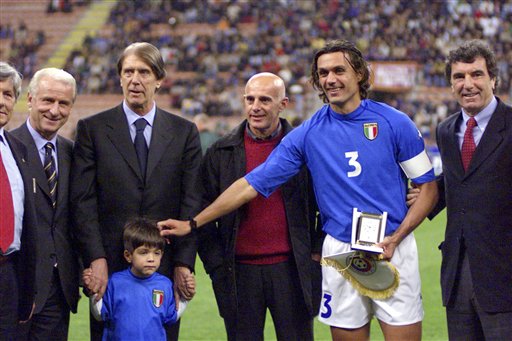 In this file  photo, former AC Milan player and national team coach Cesare Maldini, second from left, holds hands with his nephew Christian, son of Paolo Maldini, second from right, as they pose with then Italian national soccer team coach Giovanni Trapattoni, left, former national coaches Arrigo Sacchi, center, and Dino Zoff. Maldini died in Milan at the age of 84. AP