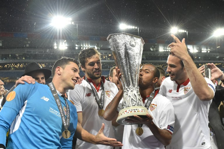 (L to R) Sevilla's Spanish goalkeeper David Soria, Sevilla's Spanish defender Fernando Llorente, Sevilla's Brazilian defender Mariano Ferreira and Sevilla's French defender Adil Rami celebrate with the trophy after winning the UEFA Europa League final football match between Liverpool FC and Sevilla FC at the St Jakob-Park stadium in Basel, on May 18, 2016.  AFP
