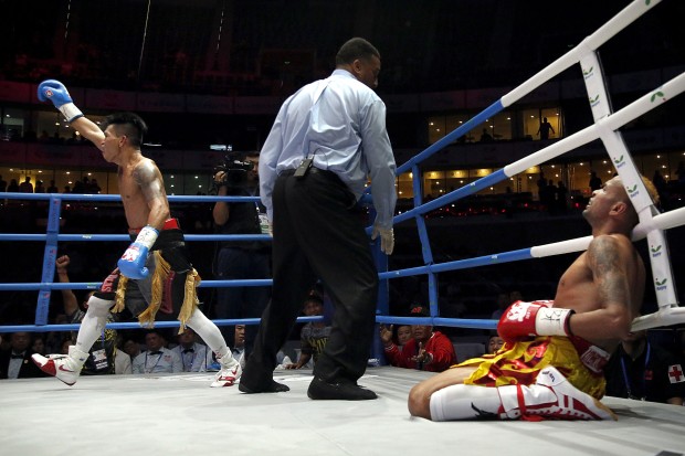 John Casimero of the Philippines, left, celebrates after beating Amnat Auenroeng of Thailand, in their IBF Flyweight Championship boxing match at the National Tennis Center in Beijing, Wednesday, May 25, 2016. Casimero defeated Auenroeng with a fourth-round knockout to claim the IBF world title. (AP Photo/Mark Schiefelbein)