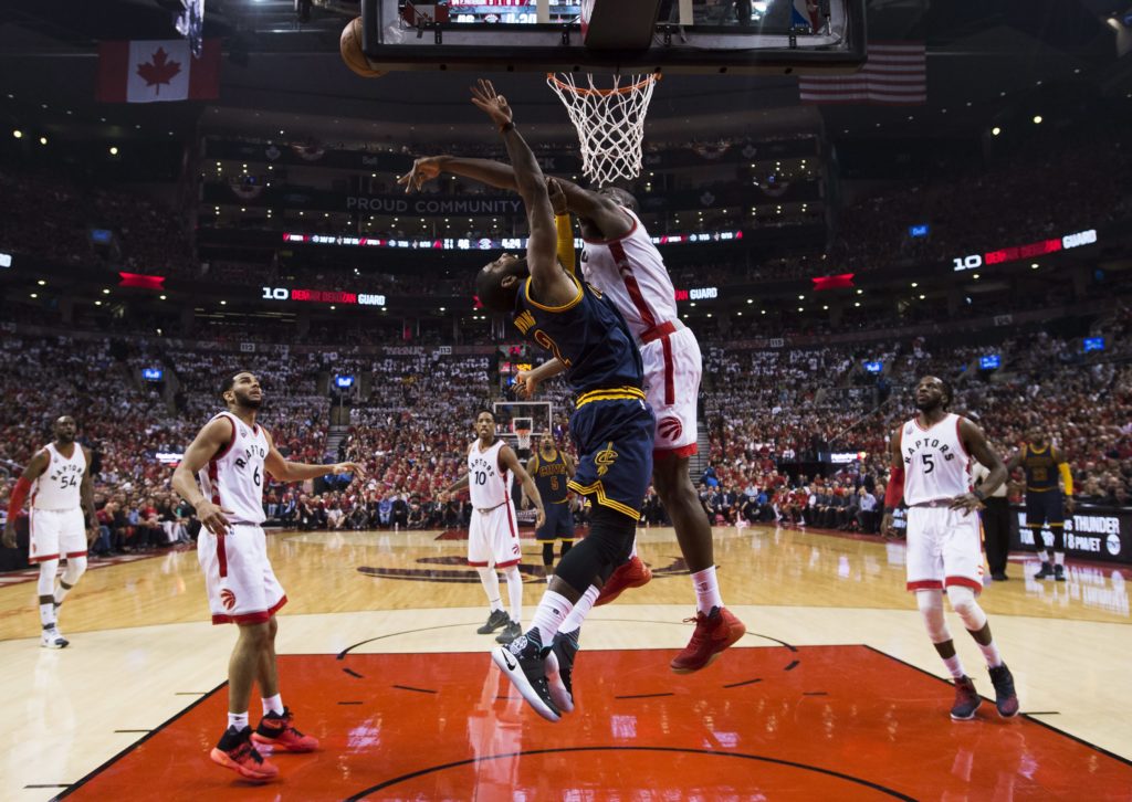 Toronto Raptors center-forward Bismack Biyombo, center right, stops Cleveland Cavaliers guard Kyrie Irving during the first half of Game 3 of the NBA basketball Eastern Conference finals in Toronto on Saturday, May 21, 2016. (Nathan Denette/The Canadian Press via AP) MANDATORY CREDIT