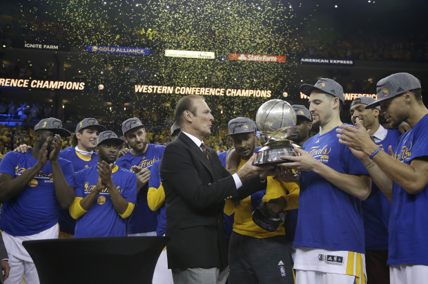 Former NBA player Rick Barry, center, presents the Western Conference finals trophy to Golden State Warriors guard Klay Thompson, second from right, after the Warriors beat the Oklahoma City Thunder in Game 7 of the NBA basketball Western Conference finals in Oakland, Calif., Monday, May 30, 2016. The Warriors won 96-88. (AP Photo/Marcio Jose Sanchez, Pool)