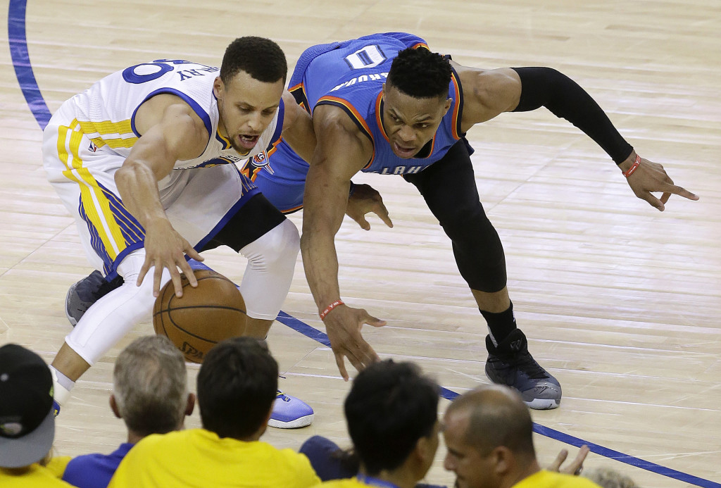 Golden State Warriors guard Stephen Curry, left, is defended by Oklahoma City Thunder guard Russell Westbrook during the second half of Game 1 of the NBA basketball Western Conference finals in Oakland, Calif., Monday, May 16, 2016. The Thunder won 108-102. (AP Photo/Jeff Chiu)