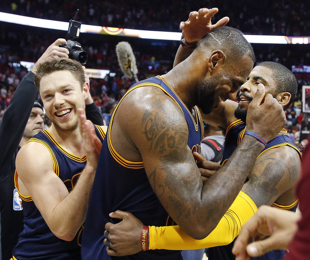 Cleveland Cavaliers' LeBron James (23) celebrates with Kyrie Irving, right, and Matthew Dellavedova (8) after  Game 4 of the second-round NBA basketball playoff series against the Atlanta Hawks, Sunday, May 8, 2016, in Atlanta. Cleveland won 100-99 and won the best-of-seven series 4-0. AP