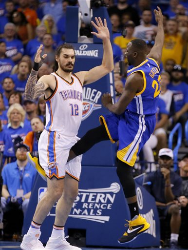 In this Sunday, May 22, 2016 photo, Golden State's Draymond Green's leg is between the legs of Oklahoma City's Steven Adams (12) during Game 3 of the Western Conference NBA basketball  finals in Oklahoma City. Green's kick to Steven Adams' groin could complicate Golden State's chance to repeat as NBA champion. The Warriors trail the Thunder 2-1.  (Bryan Terry/The Oklahoman via AP) 