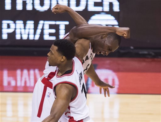 Toronto Raptors center Bismack Biyombo (8) celebrates with guard Kyle Lowry (7) while playing against the Cleveland Cavaliers during second half Eastern Conference final playoff basketball action in Toronto on Monday, May 23, 2016. Toronto won, 105-99. (Nathan Denette/The Canadian Press via AP) 