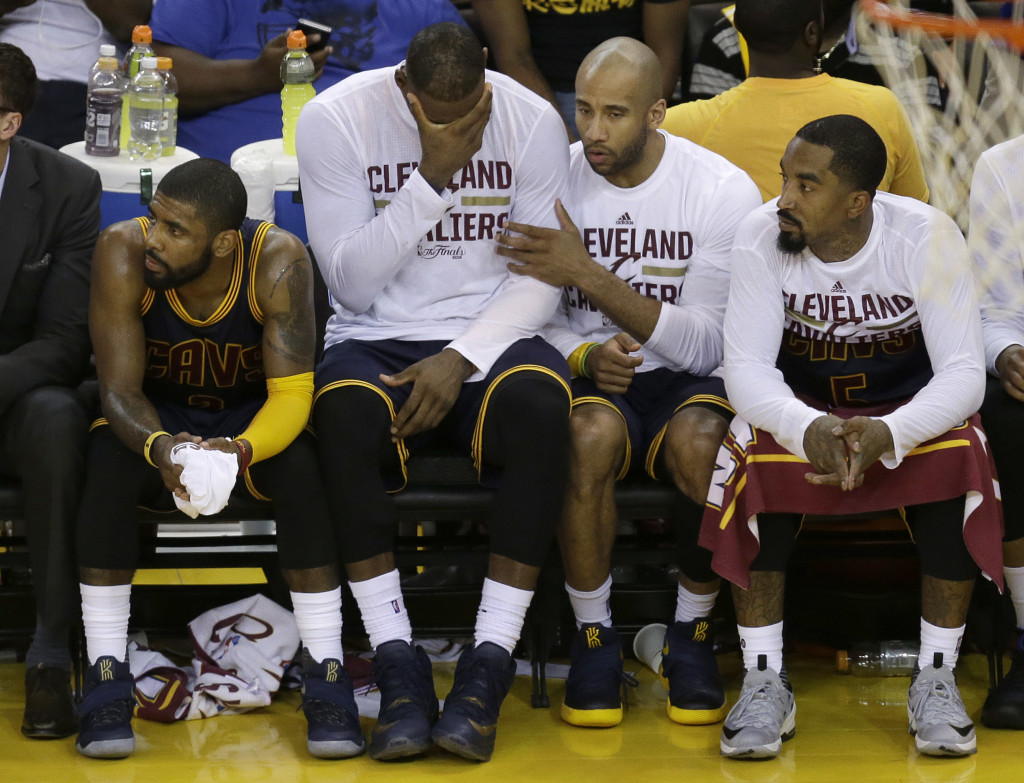 Cleveland Cavaliers' Kyrie Irving, from left, LeBron James, Dahntay Jones and J.R. Smith sit on the bench during the second half of Game 2 of basketball's NBA Finals against the Golden State Warriors in Oakland, Calif., Sunday, June 5, 2016. (AP Photo/Ben Margot)