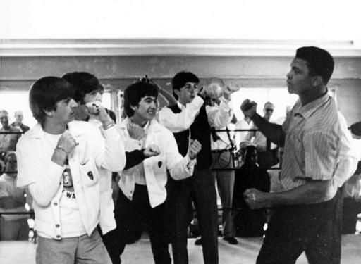 FILE - In this Feb. 18, 1964, file photo, the Beatles, from left, Ringo Starr, John Lennon, George Harrison, and Paul McCartney spar up to Muhammad Ali, or Cassius Clay at the time, while visiting the heavyweight contender at his training camp in Miami Beach, Fla.   Ali, the magnificent heavyweight champion whose fast fists and irrepressible personality transcended sports and captivated the world, has died according to a statement released by his family Friday, June 3, 2016. He was 74.  (AP Photo/File)