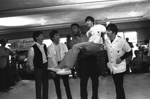 FILE - In this Feb. 18, 1964, file photo, boxer Cassius Clay (Muhammad Ali) lifts Ringo Starr, one of the Beatles, into the air while the singers visited Clay's camp in Miami Beach, Fla. Others are, from left: Paul McCartney, George Harrison, and John Lennon. Ali, the magnificent heavyweight champion whose fast fists and irrepressible personality transcended sports and captivated the world, has died according to a statement released by his family Friday, June 3, 2016. He was 74.  (AP Photo/File)