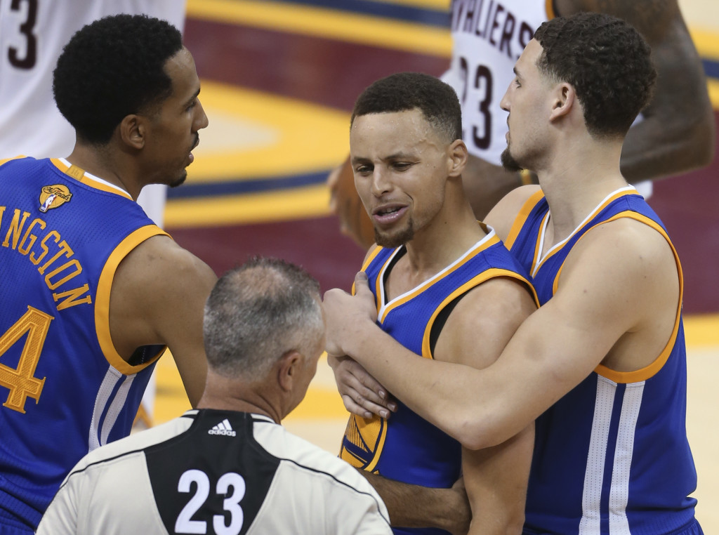 Golden State Warriors guard Stephen Curry is held back from referee Jason Phillips (23) by Shaun Livingston, left, and Klay Thompson, right, while reacting to being called for his sixth foul on Cleveland Cavaliers forward LeBron James (23) during the second half of Game 6 of basketball's NBA Finals in Cleveland, Thursday, June 16, 2016. (AP Photo/Ron Schwane)