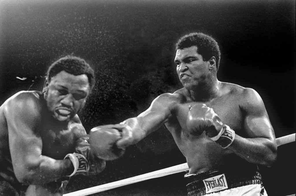 FILE-- Spray flies from the head of challenger Joe Frazier as heavyweight champion Muhammad Ali connects with a right in the ninth round of their title fight in Manila, Philippines, in this Oct. 1, 1975 file photo.  Ali won the fight on a decision to retain the title.  (AP Photo/Mitsunori Chigita)