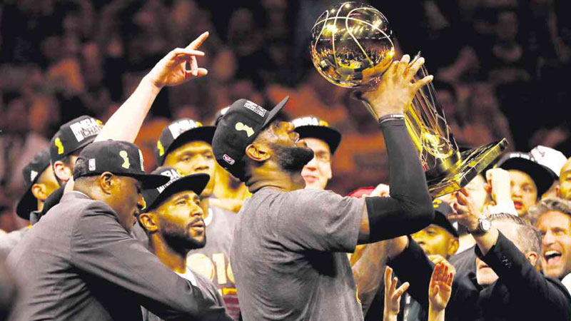 EPIC WIN LeBron James raises the Larry O’Brien Championship Trophy after the Cleveland Cavaliers defeated the Golden State Warriors 93-89 in Game 7 to win the 2016 NBA Finals at Oracle Arena on Sunday in Oakland, California. AFP