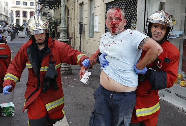 A man is taken away by emergency service workers after he was injured in clashes in downtown Marseille, France, Saturday, June 11, 2016. Riot police have thrown tear gas canisters at soccer fans Saturday in Marseille's Old Port in a third straight day of violence in the city. AP