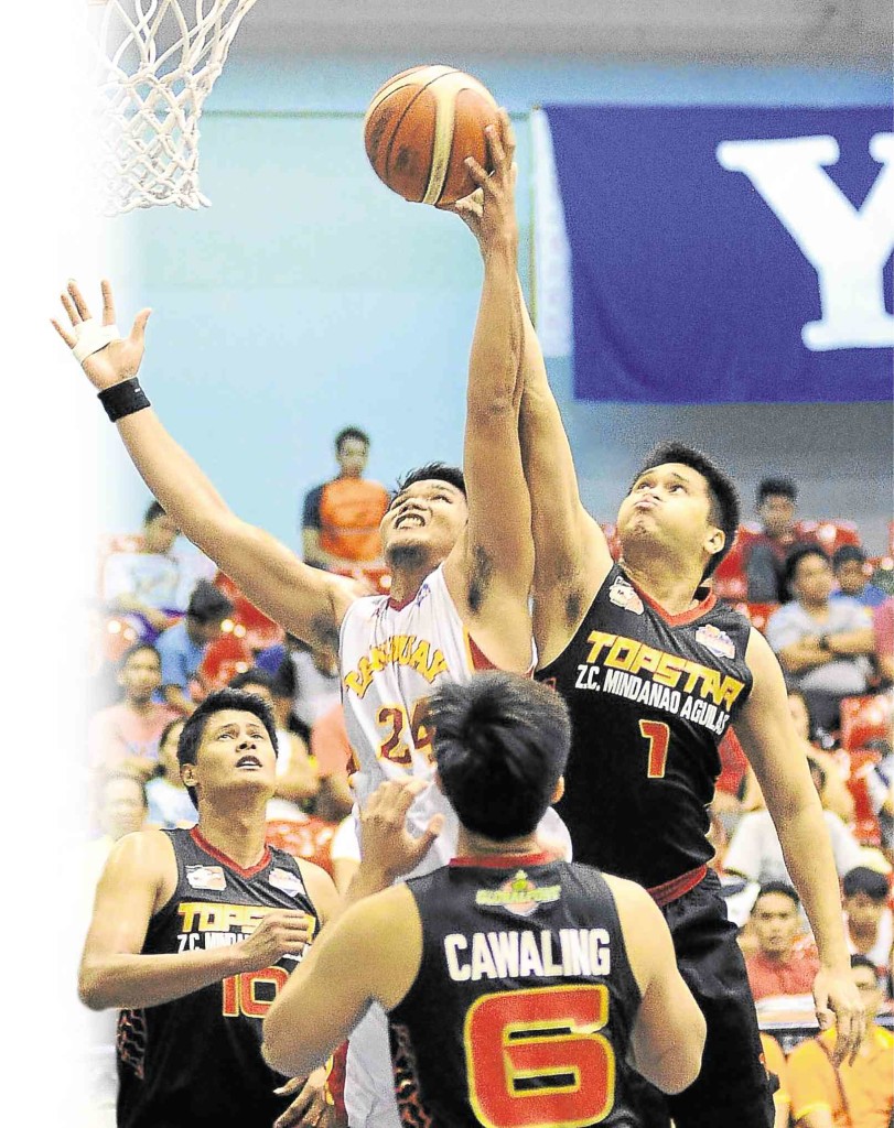 Mindanao Aguilas’ Mark Acosta (right) elevates to palm away a shot by Jovet Mendoza of Tanduay in yesterday’s game at Ynares Sports Arena. AUGUST DELA CRUZ