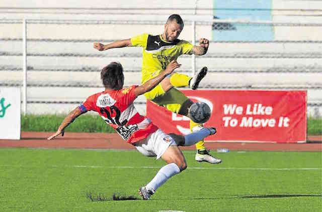 CERES midfielder Stephan Schrock goes for a shot against JP Voltes defender Masaki Yanagawa in Saturday night’s key UFL match at Rizal Memorial Stadium. Ceres prevailed to vault into the lead. UFL PHOTO