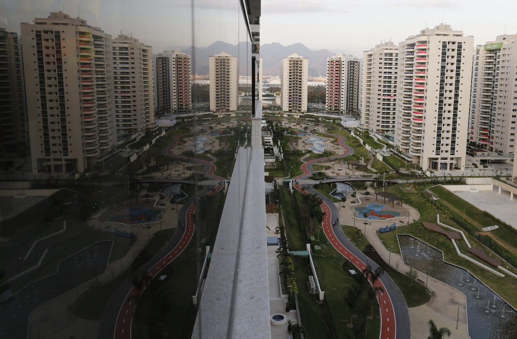 The Olympic Village is reflected in an apartment window in Rio de Janeiro, Brazil, Saturday, July 23, 2016. The brand new complex of residential towers are where nearly 11,000 athletes and some 6,000 coaches and other handlers will sleep, eat and train during the upcoming games, that will kickoff on Aug. 5(AP Photo/Leo Correa)