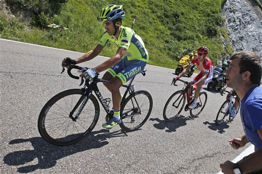 Spain's Alberto Contador, left, strains as he rides in the back of the pack with France’s Nicolas Edet, right, during the ninth stage of the Tour de France cycling race over 184.5 kilometers (114.3 miles) with start in Vielha Val d'Aran, Spain, and finish in Andorra Arcalis, Andorra, Sunday, July 10, 2016.  AP Photo/Christophe Ena