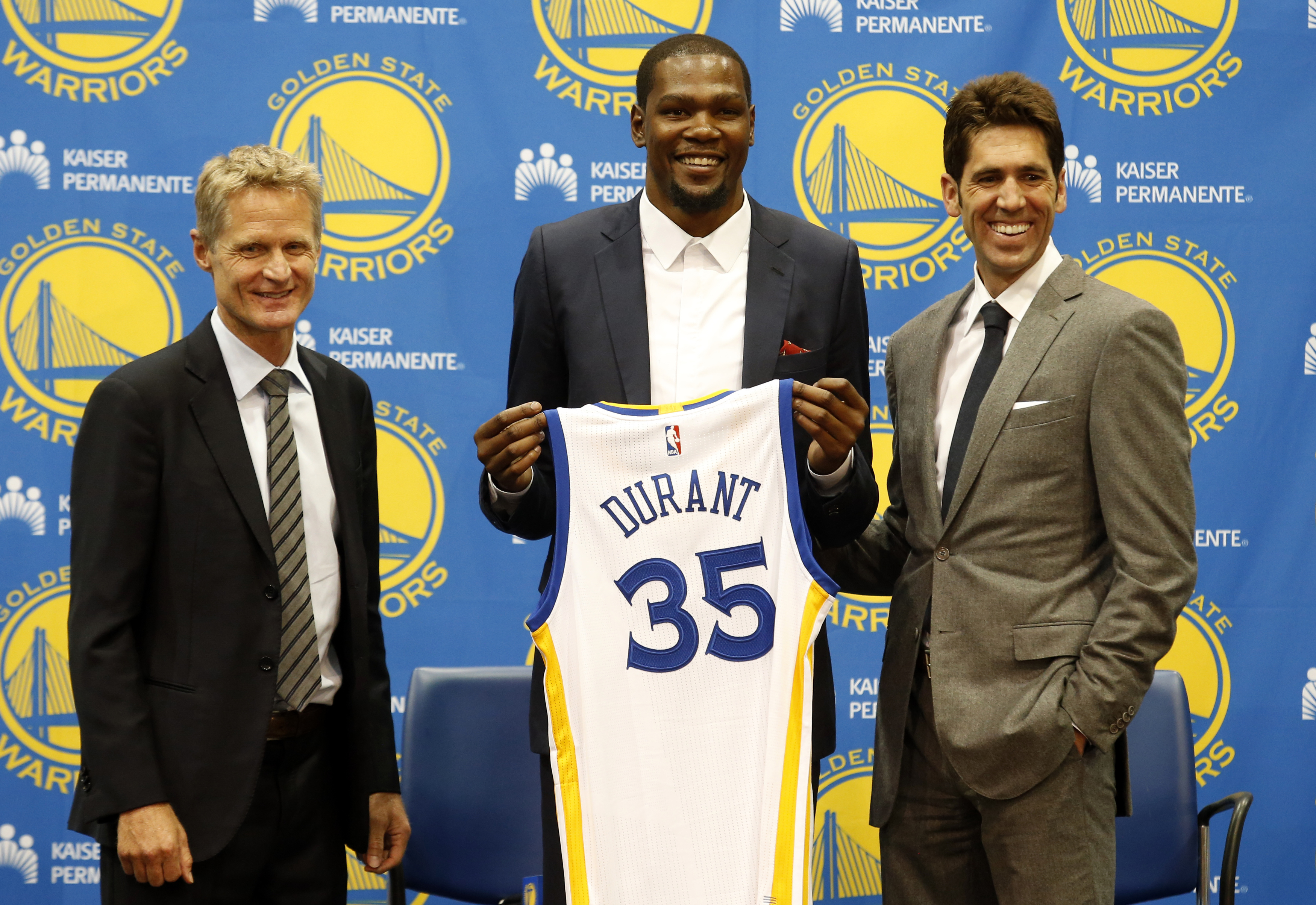 Golden State Warriors' newest player Kevin Durant, center, joins head coach Steve Kerr, left and general manager Bob Myers during a news conference at the NBA basketball team's practice facility, Thursday, July 7, 2016, in Oakland, California. AP