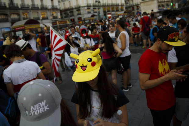 FILE - In this Thursday, July 28, 2016, file photo, fans play the highly addictive "Pokemon Go" game during a gathering in central Madrid, Spain, to play the computer game. Since debuting to wild adulation in the U.S., Australia and New Zealand this month, the game from Google spinoff Niantic Inc. has spread like wildfire, launching in more than 30 countries or territories, but not Brazil. For athletes and other visitors caught up in the wave, not having access is just one more knock against an Olympics that officials are racing to get ready. The opening ceremony takes place Friday, Aug. 5. (AP Photo/Daniel Ochoa de Olza, File)