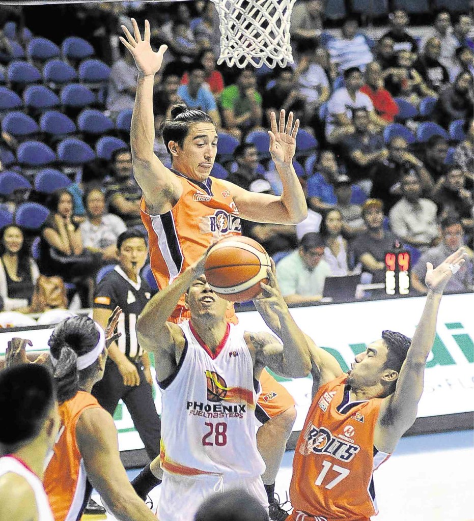 WILLIE Wilson of Phoenix tries to put up a shot under pressure from Anjo Caram (right) and Cliff Hodge of Meralco in last night’s game. AUGUST DELA CRUZ