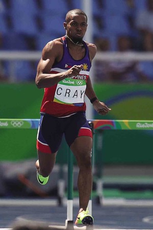 DESPITE an errant glance near the finish line, Eric Cray still reaches the 400-meter hurdles. TED S. MELENDRES 
