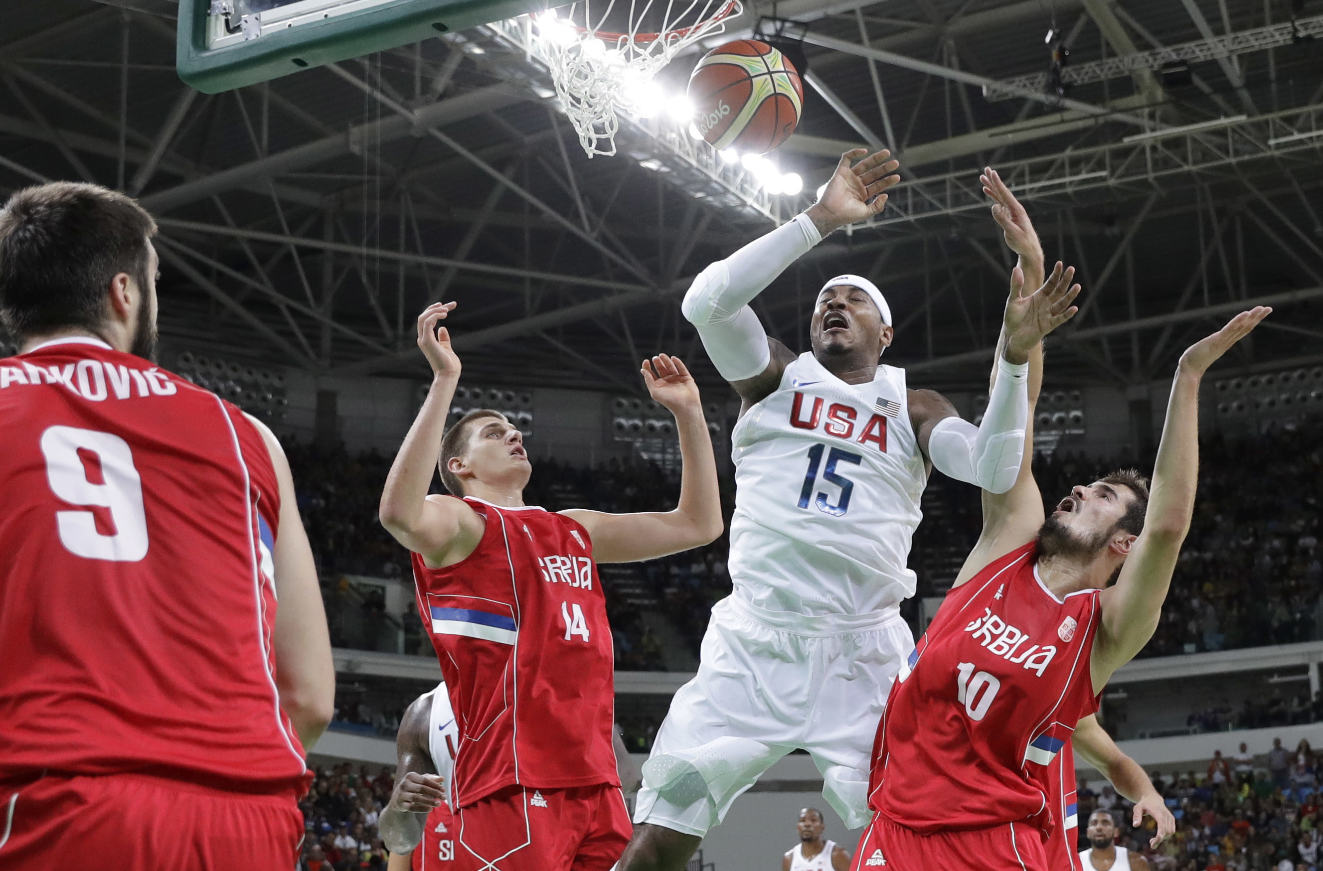 United States' Carmelo Anthony (15) fouled as he drives to the basket between Serbia's Nikola Jokic (14) and Nikola Kalinic (10) is during a men's basketball game at the 2016 Summer Olympics in Rio de Janeiro, Brazil, Friday, Aug. 12, 2016. AP