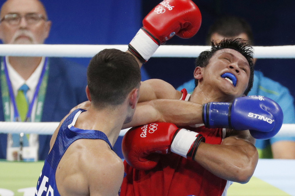 BRITAIN’S Joseph Cordina (in blue) connects with a left to the face of the Philippines’ Charly Suarez during their men’s lightweight match Saturday. AP