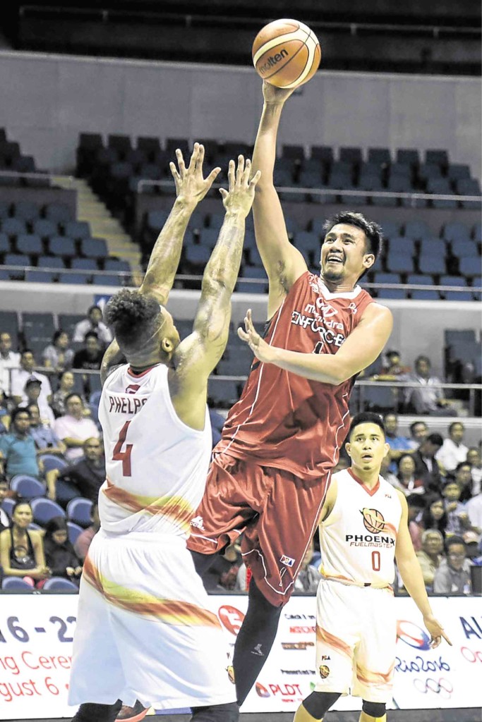 ALDRECH Ramos of Mahindra soars for a layup off the outstretched arms of Phoenix import Eugene Phelps. Sherwin Vardeleon