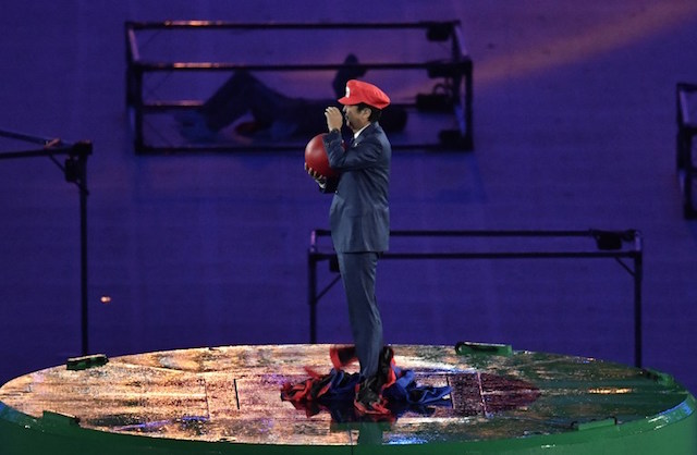 Japanese Prime Minister Shinzo Abe, dressed as Super Mario, holds a red ball during the closing ceremony of the Rio 2016 Olympic Games at the Maracana stadium in Rio de Janeiro on August 21, 2016. / AFP PHOTO / PHILIPPE LOPEZ